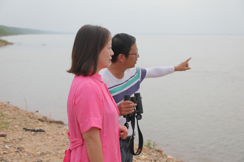 自愿者徐建利（右），，，，向王琼解说江豚拍摄点位和寓目角度。。h49a1727.jpg